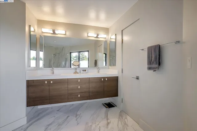 a bathroom with a sink double vanity granite and a mirror