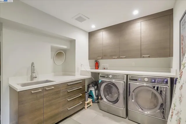 a utility room with sink dryer and washer
