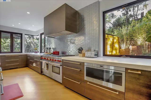 a kitchen with stainless steel appliances a stove and a large window