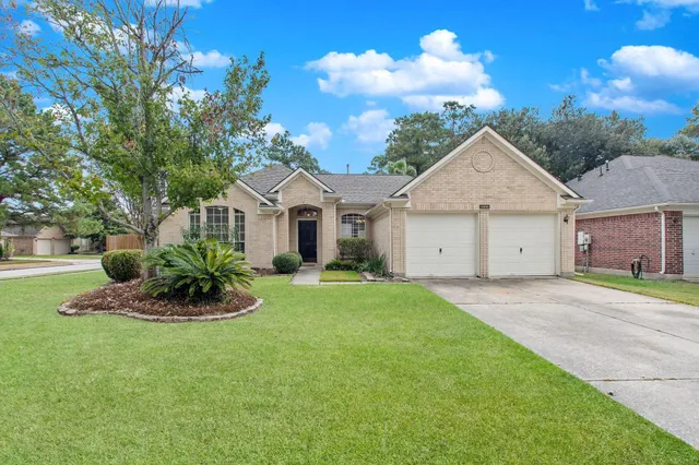 a white house with a big yard and large trees