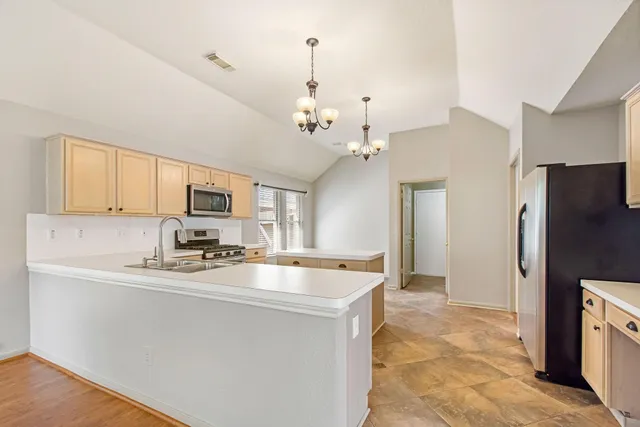 a kitchen with stainless steel appliances a stove refrigerator sink and microwave