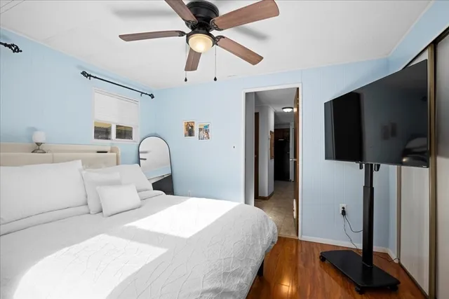 a bedroom with a bed and a flat tv screen on dresser