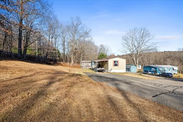 a front view of a house with a yard and covered with snow
