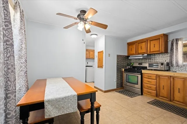 a kitchen with stainless steel appliances kitchen island granite countertop a refrigerator a stove top oven a sink with island and chairs