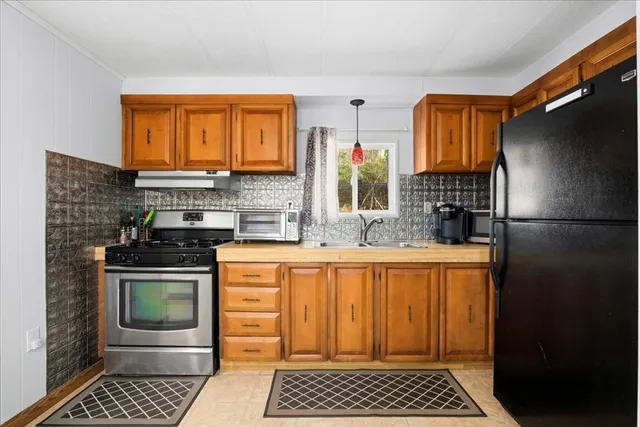 a kitchen with stainless steel appliances granite countertop a refrigerator and a sink