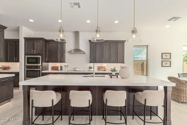 a kitchen with granite countertop a dining table chairs and white cabinets