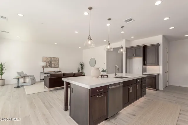 a large kitchen with a counter space a sink stainless steel appliances and cabinets