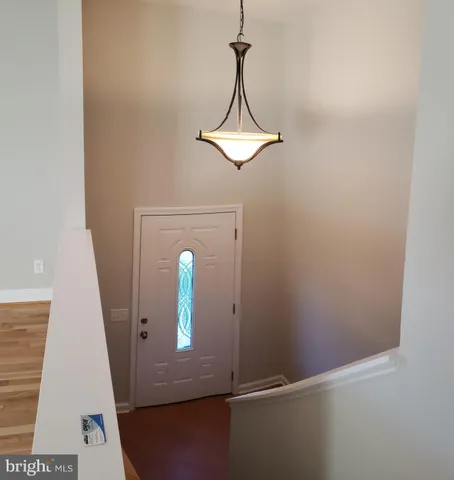 a view of a hallway with wooden floor and entryway