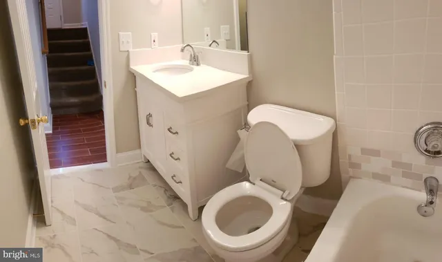 a bathroom with a sink a toilet and bathtub