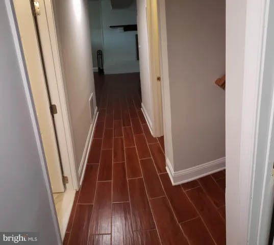 an empty room with wooden floor a fireplace and windows