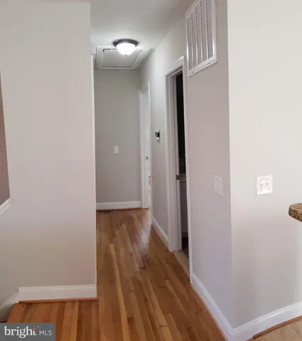 a view of a hallway with wooden floor