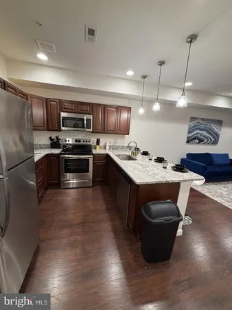 a kitchen with stainless steel appliances granite countertop a stove a sink dishwasher a microwave oven and a refrigerator