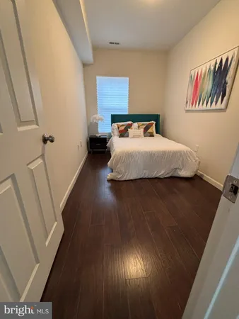 a bedroom with a bed and a painting on the wall
