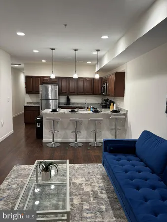 a kitchen with stainless steel appliances granite countertop a sink a stove a microwave a refrigerator and a cabinets