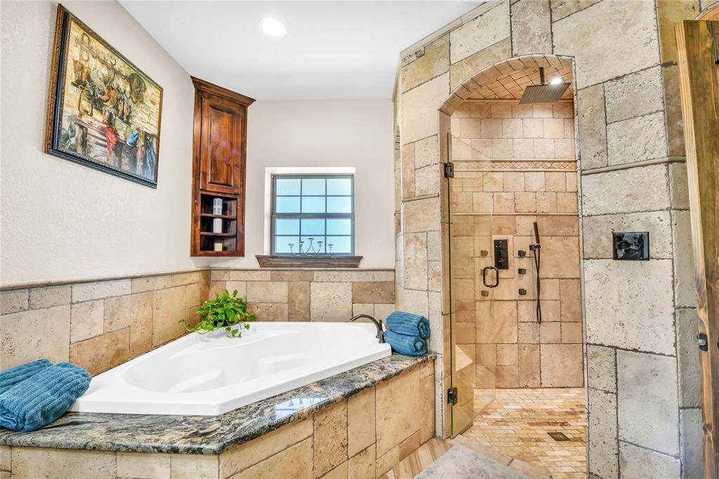 854 County Road 3330 Bridgeport, TX 76426 - Photo 14 of 40 Over sized soaking tub trimmed in granite and surrounded by tile.