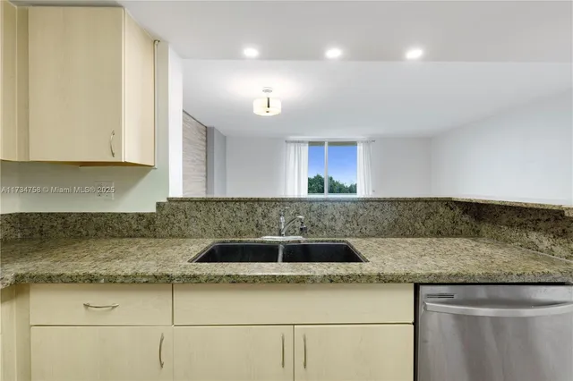 a kitchen with granite countertop a sink and a stove