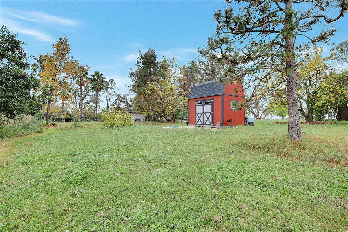 4667 Fruitland Road Marysville, CA 95901 - Photo 39 of 42 a brick house with a big yard and large trees