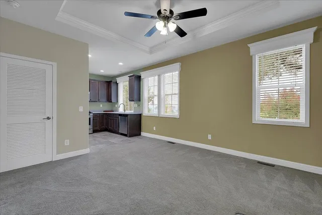 a view of empty room with windows and ceiling fan
