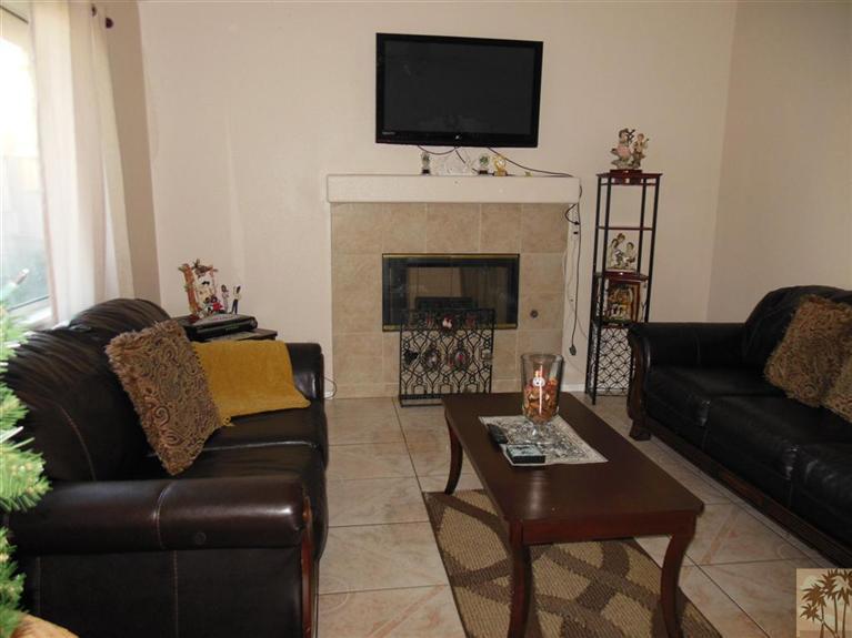 66033 Santa Rosa Road Desert Hot Springs, CA 92240 - Photo 2 of 21 a living room with furniture a flat screen tv and a fireplace