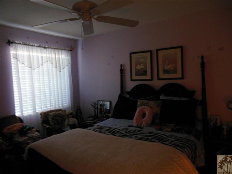 66033 Santa Rosa Road Desert Hot Springs, CA 92240 - Photo 14 of 21 a bedroom with a bed next to a window and desk