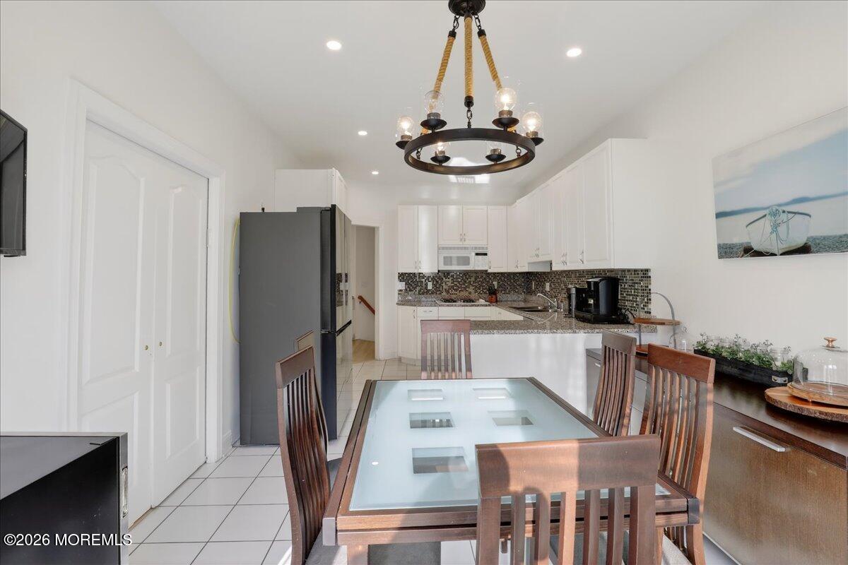 21 Riviera Drive Long Branch, NJ 07740 - Photo 22 of 64 a kitchen with stainless steel appliances granite countertop a refrigerator a stove a sink dishwasher a dining table and chairs with wooden floor