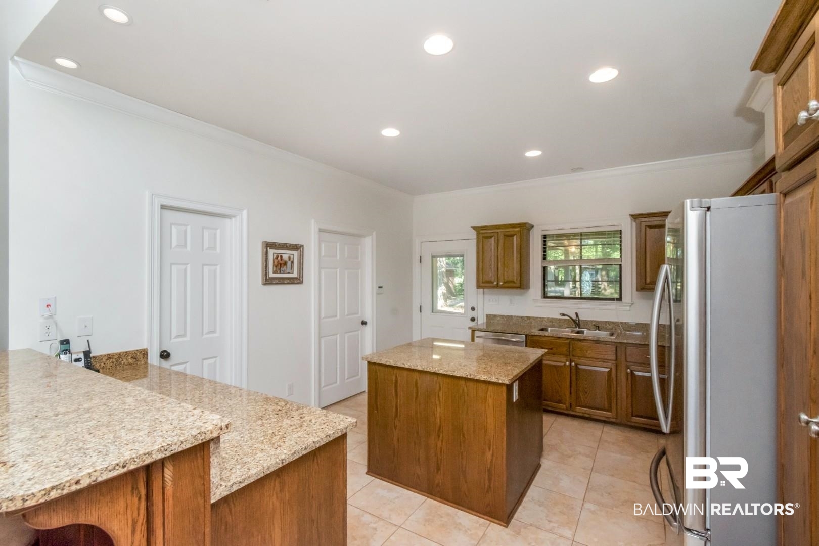 1360 Dykes Road North Mobile, AL 36608 - Photo 11 of 40 Kitchen with a center island, appliances with stainless steel finishes, recessed lighting, ornamental molding, and brown cabinets