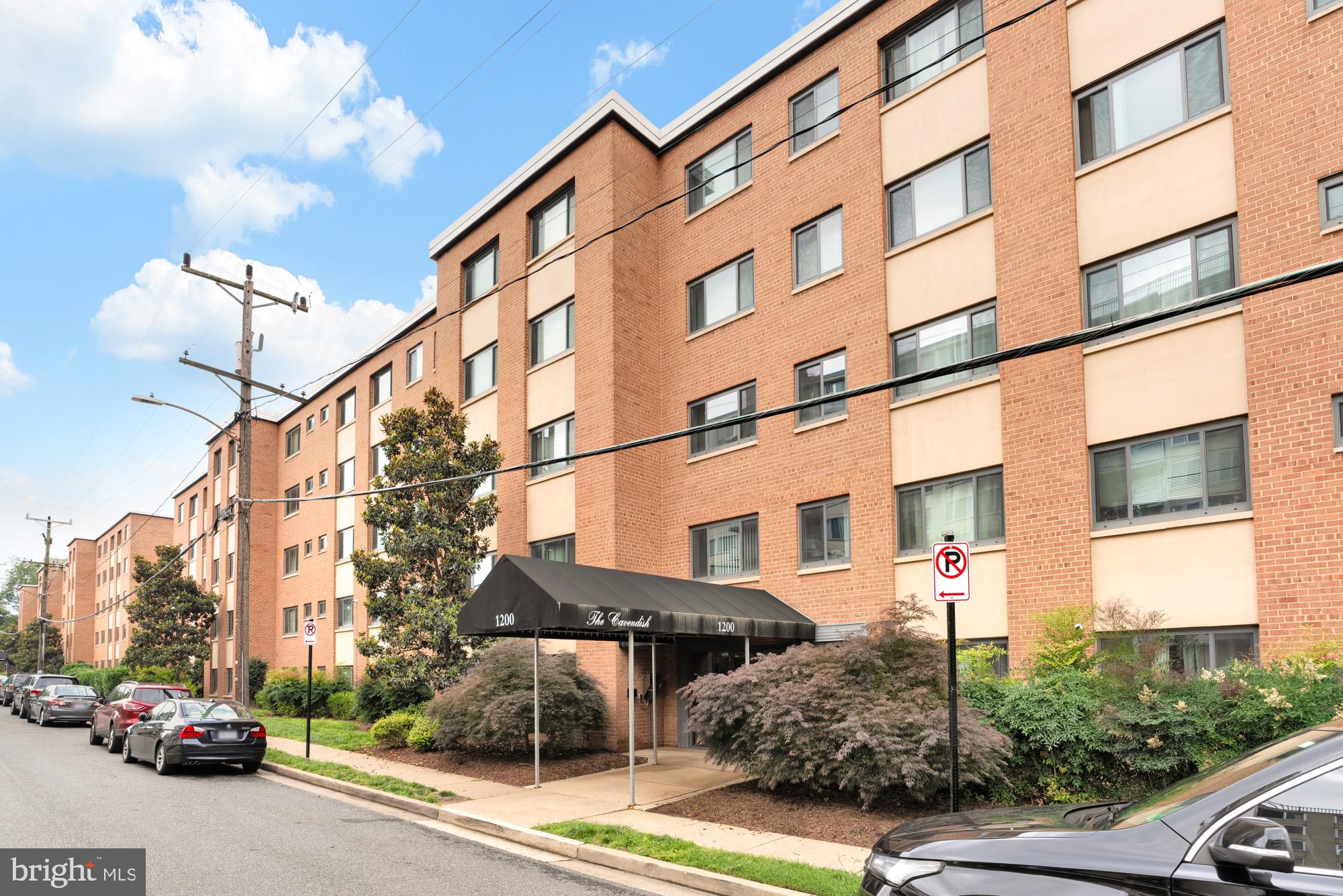 a city street lined with parked cars and buildings