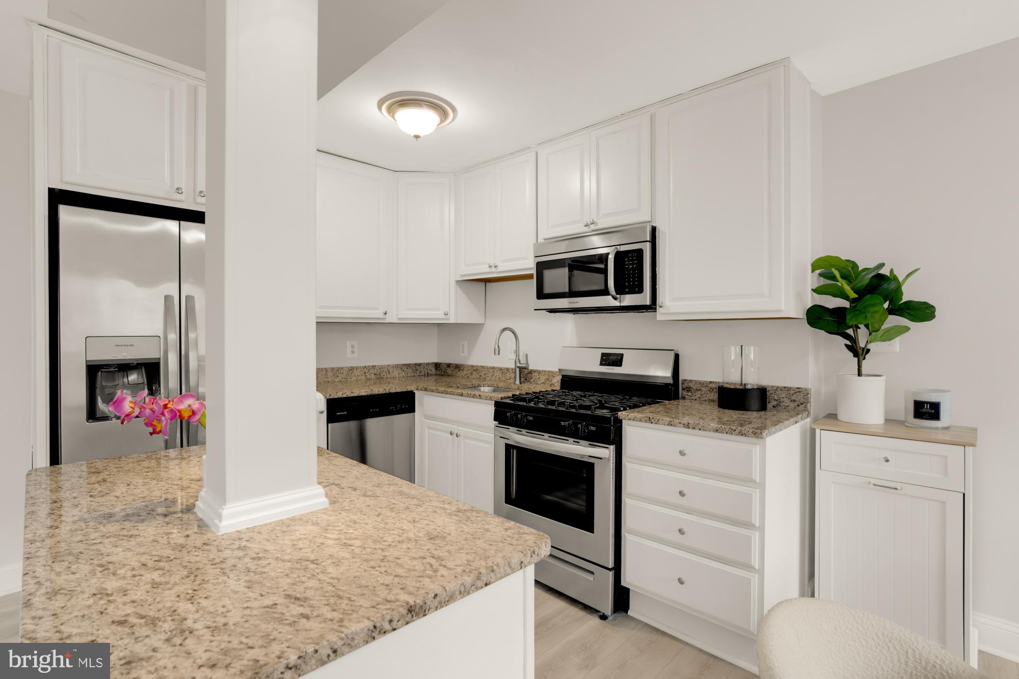 1200 South Arlington Ridge Road, Unit 507 Arlington, VA 22202 - Photo 16 of 30 a kitchen with granite countertop a sink stainless steel appliances and white cabinets