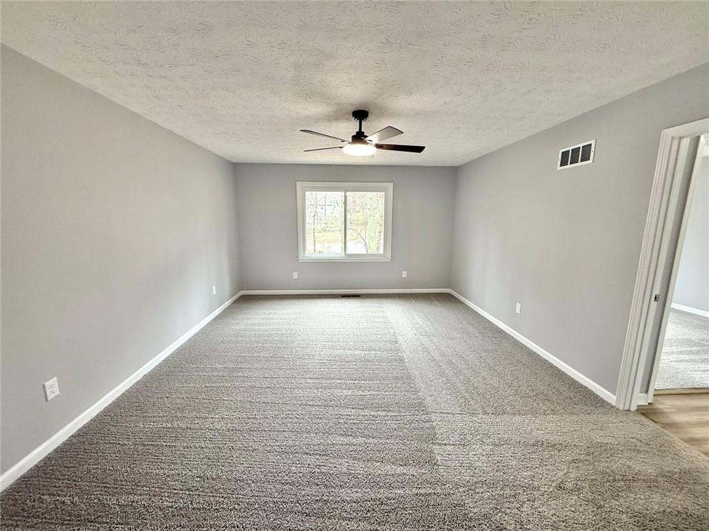 3851 Riding Woods Court Powder Springs, GA 30127 - Photo 18 of 32 an empty room with windows and ceiling fan