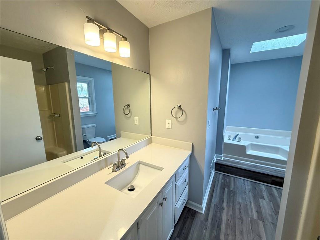 3851 Riding Woods Court Powder Springs, GA 30127 - Photo 20 of 32 a bathroom with a double vanity sink a mirror and a bathtub