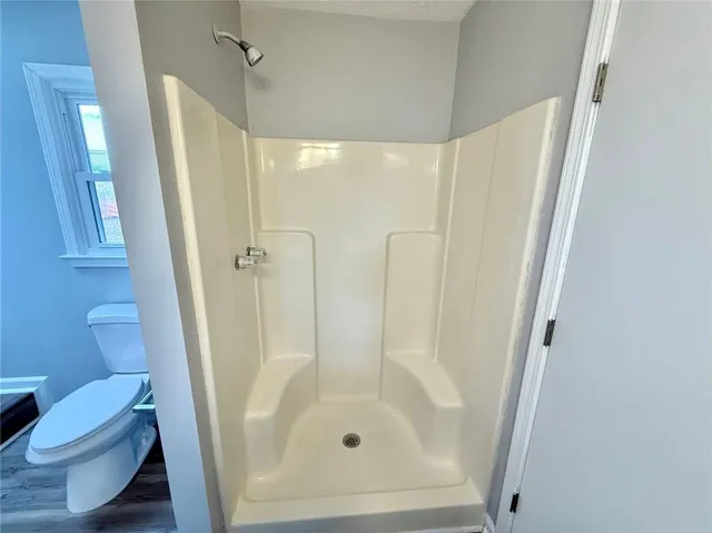 a bathroom with a glass door shower and toilet