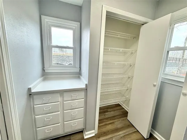 a view of walk in closet with wooden floor