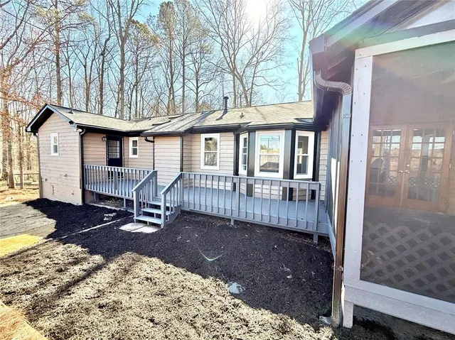 a backyard of a house with large trees and wooden fence
