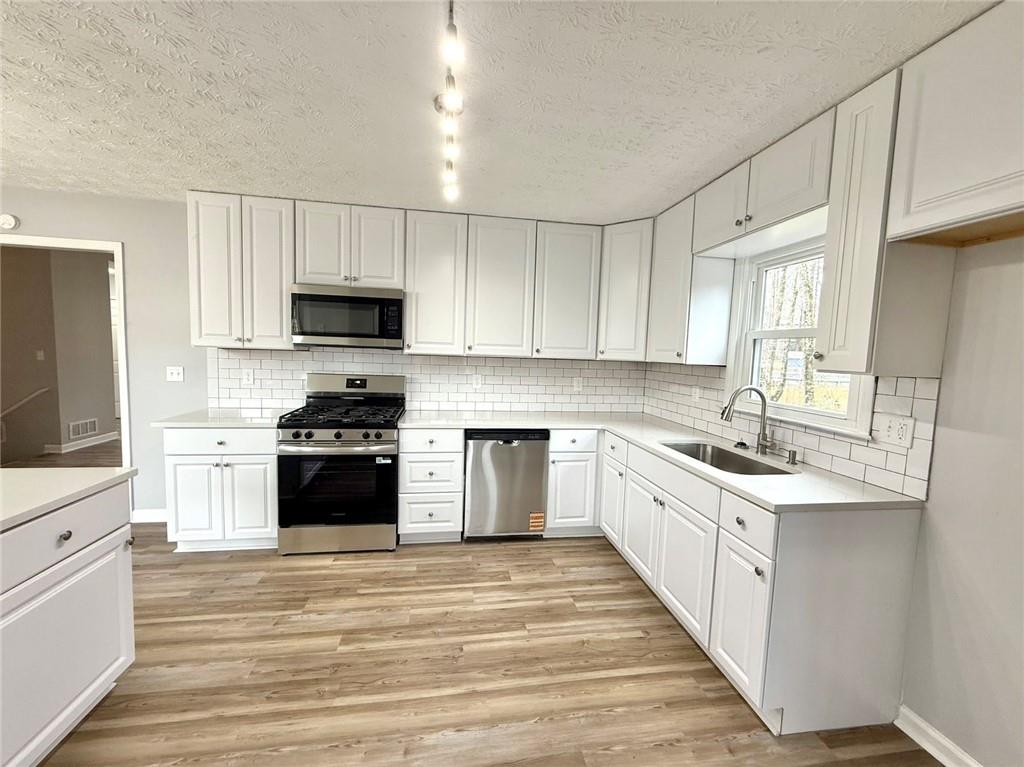 3851 Riding Woods Court Powder Springs, GA 30127 - Photo 10 of 32 a kitchen with stainless steel appliances a sink stove top oven and cabinets