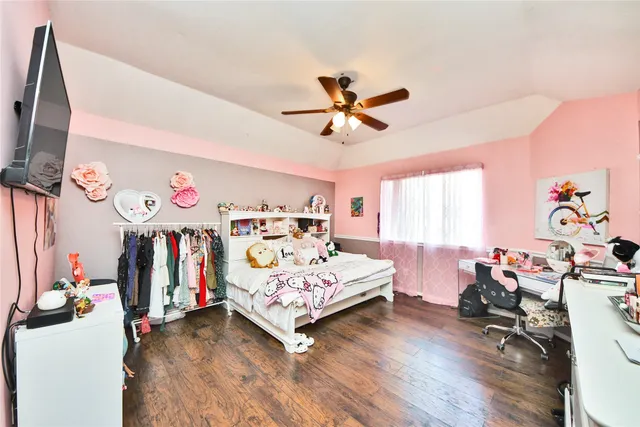 a bedroom with a bed and a flat tv screen on dresser