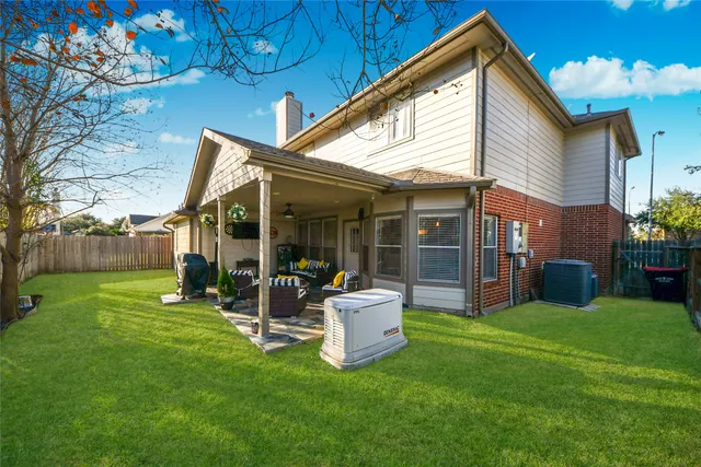 a view of a backyard with table and chairs and a barbeque with potted plants