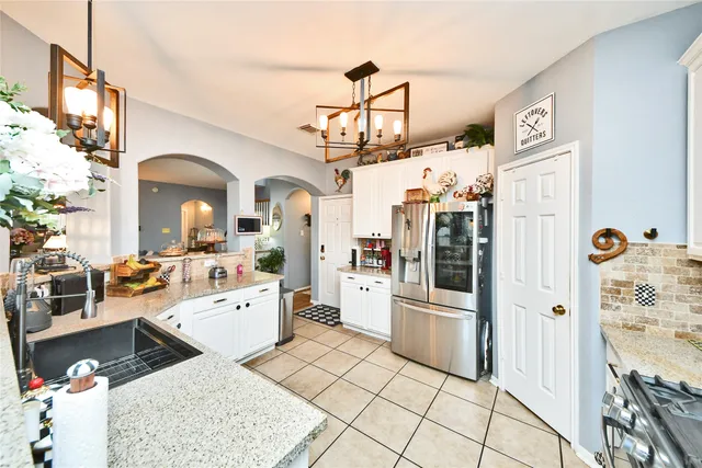 a very nice looking open kitchen with stainless steel appliances granite countertop a stove and a refrigerator