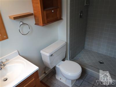 19 Kanan Road Oak Park, CA 91377 - Photo 6 of 12 a white toilet sitting next to a bathroom sink and a mirror