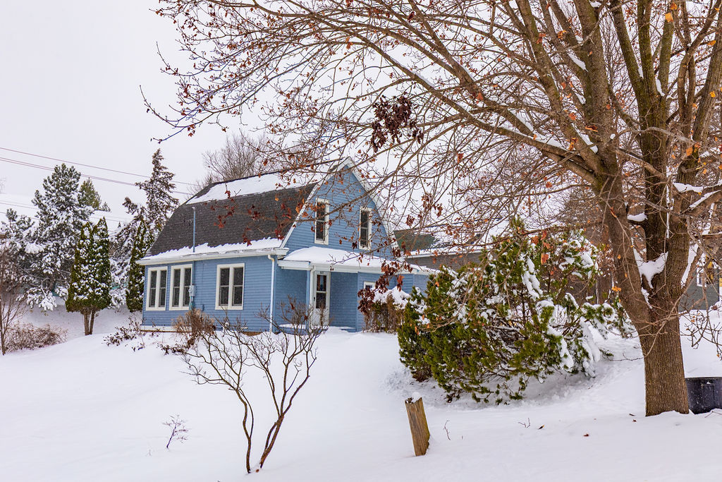 a view of a house with a yard covered in snow