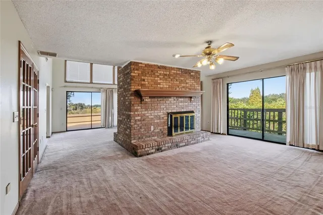 a view of an empty room with a fireplace and a window