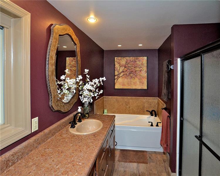 111 McDermott Road Trafford, PA 15085 - Photo 13 of 25 Master bath with elongated vanity, bubble tub, walk-in shower, recessed lighting, water closet, and wood plank tile flooring.