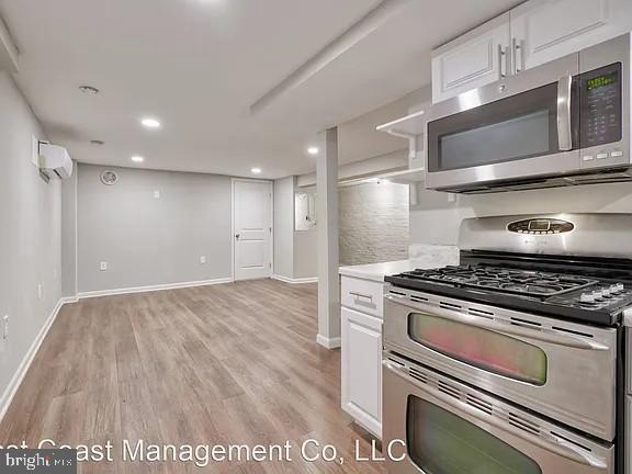 917 North Calvert Street, Unit 1 Baltimore, MD 21202 - Photo 6 of 24 a kitchen with a stove and a microwave