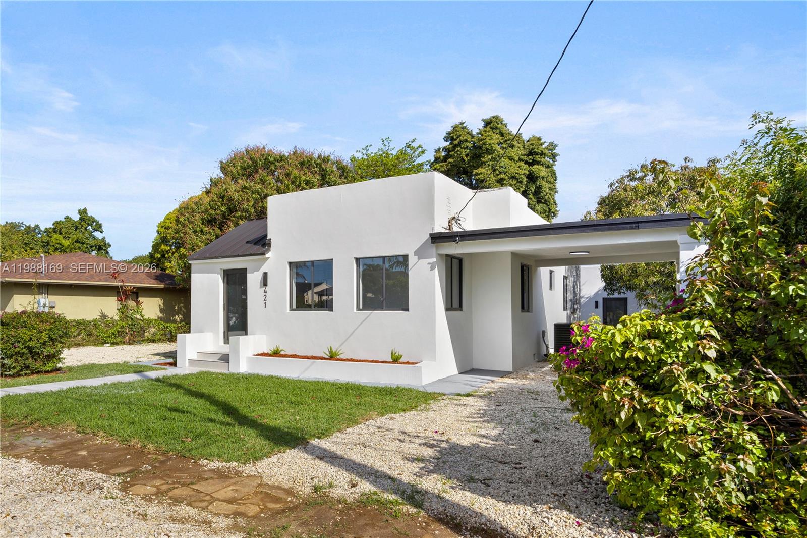 421 Northwest 81st Street Miami, FL 33150 - Photo 2 of 39 a view of a white house with a yard and potted plants