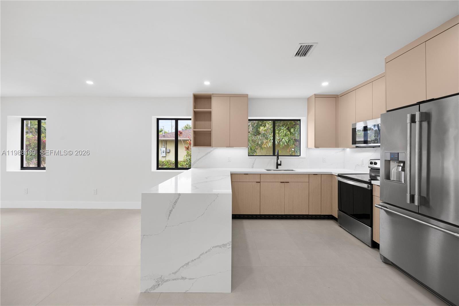 421 Northwest 81st Street Miami, FL 33150 - Photo 26 of 39 a large white kitchen with cabinets a sink a window and stainless steel appliances