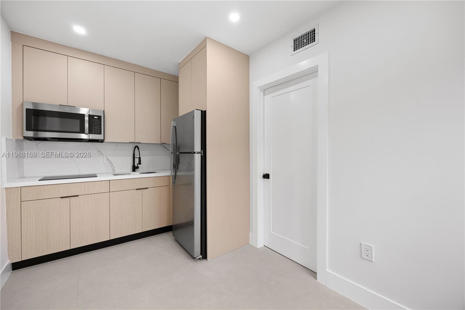 421 Northwest 81st Street Miami, FL 33150 - Photo 31 of 39 a kitchen with white cabinets and stainless steel appliances