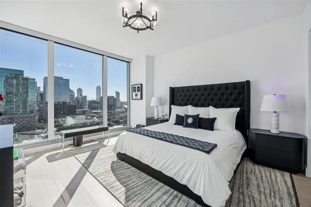 a bedroom with a large bed and a chandelier