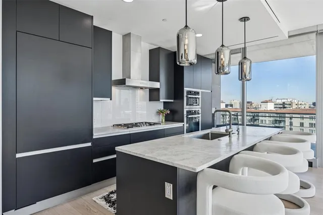 a kitchen with stainless steel appliances granite countertop a sink a refrigerator and a wooden cabinets