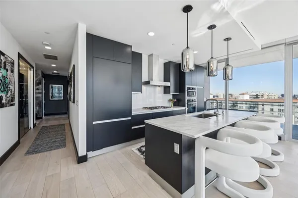 a kitchen with kitchen island sink stove and refrigerator