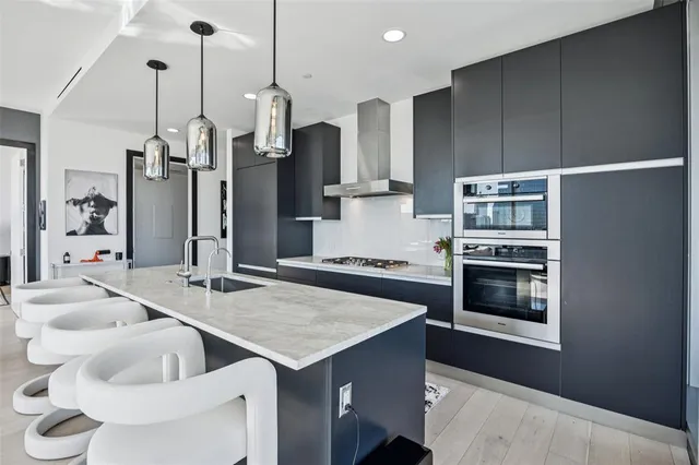a kitchen with stainless steel appliances kitchen island granite countertop a sink refrigerator and cabinets