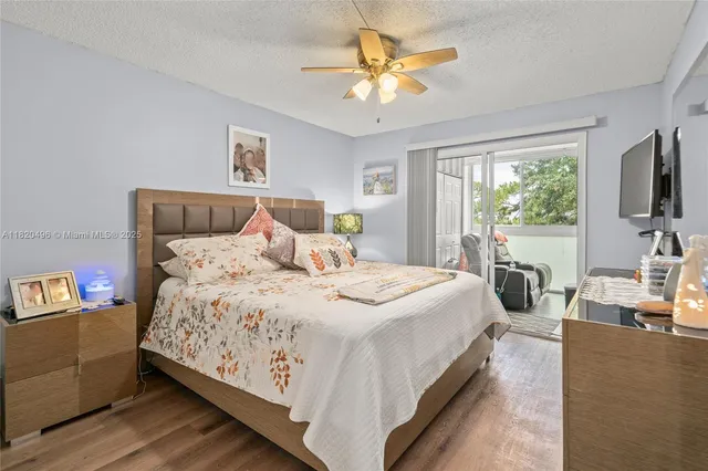 a bedroom with a bed a flat screen tv and a chandelier